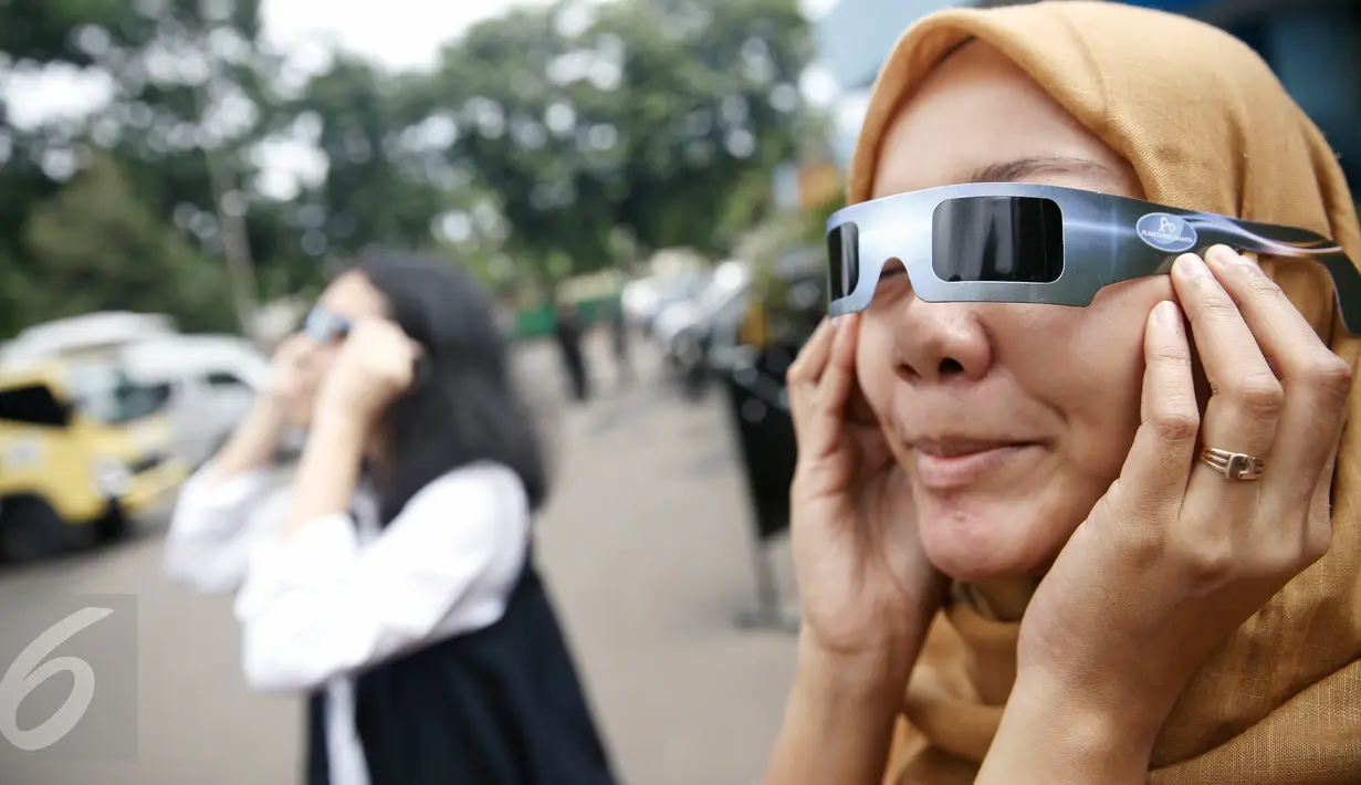 Petugas mencoba kacamata khusus yang akan digunakan saat pengamatan Gerhana Matahari Total (GMT) di Planetarium TIM Jakarta, Selasa (8/3). Planetarium akan memfasilitasi warga yang hendak menyaksikan fenomena gerhana matahari. (Liputan6.com/Faizal Fanani)