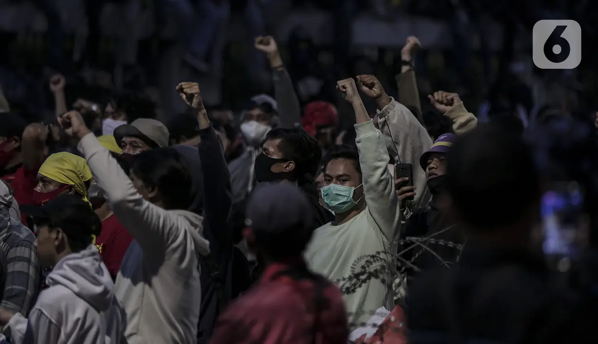 Mahasiswa dan elemen buruh bertahan hingga malam saat aksi di depan Gedung DPR/MPR/DPD, Jakarta, Kamis (16/7/2020). Dalam aksinya, mereka menolak pengesahan RUU Cipta Kerja atau Omnibus Law yang saat ini sedang dibahas DPR bersama pemerintah. (Liputan6.com/Johan Tallo)