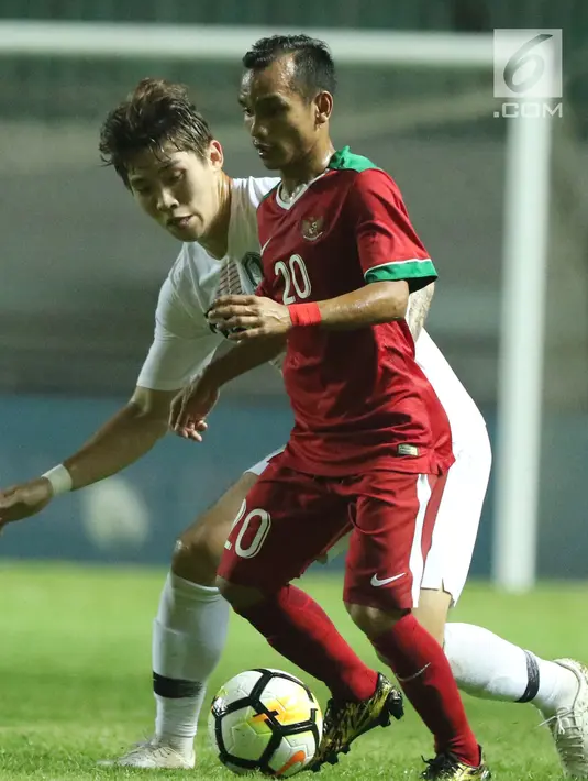 Pemain sayap timnas Indonesia U-23, Riko Simanjuntak (depan) mencoba melewati adangan pemain Korea Selatan U-23 pada laga persahabatan di Stadion Pakansari, Kab Bogor, Sabtu (23/6). Indonesia U-23 kalah 1-2. (Liputan6.com/Helmi Fithriansyah)