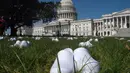 Serikat perawat Amerika Serikat (AS) meletakkan 164 pasang sepatu putih di luar US Capitol di Washington, DC pada Selasa (21/7/2020). Sepatu-sepatu itu melambangkan para perawat yang tewas akibat covid-19 dan menuntut Senat bertindak cepat melindungi perawat di garis depan. (Olivier DOULIERY/AFP)