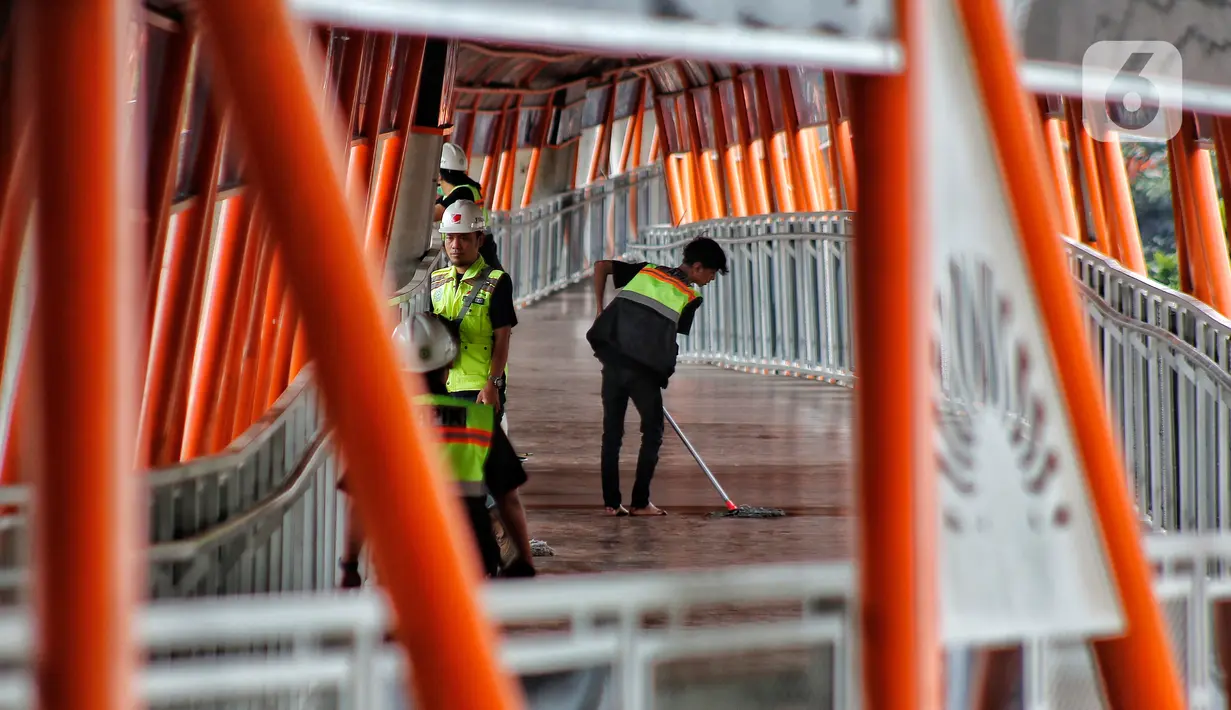 Pekerja melakukan perawatan Skybridge Kebayoran Lama, Jakarta Selatan, Kamis (26/1/2023). Pemprov DKI Jakarta akan meresmikan Skybridge Kebayoran Lama yang akan menghubungkan Halte Transjakarta Velbak ke Stasiun Kebayoran Lama. (Liputan6.com/Angga Yuniar)