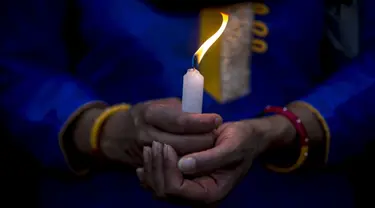 Seorang wanita menyalakan lilin untuk menghormati para korban gempa Nepal di Boudha Stupa, Kathmandu, Nepal, (7/5/2015). Gempa berkekuatan 7,8 yang meluluhlantakkan Nepal pada 25 April 2015 lalu. (REUTERS/Athit Perawongmetha)