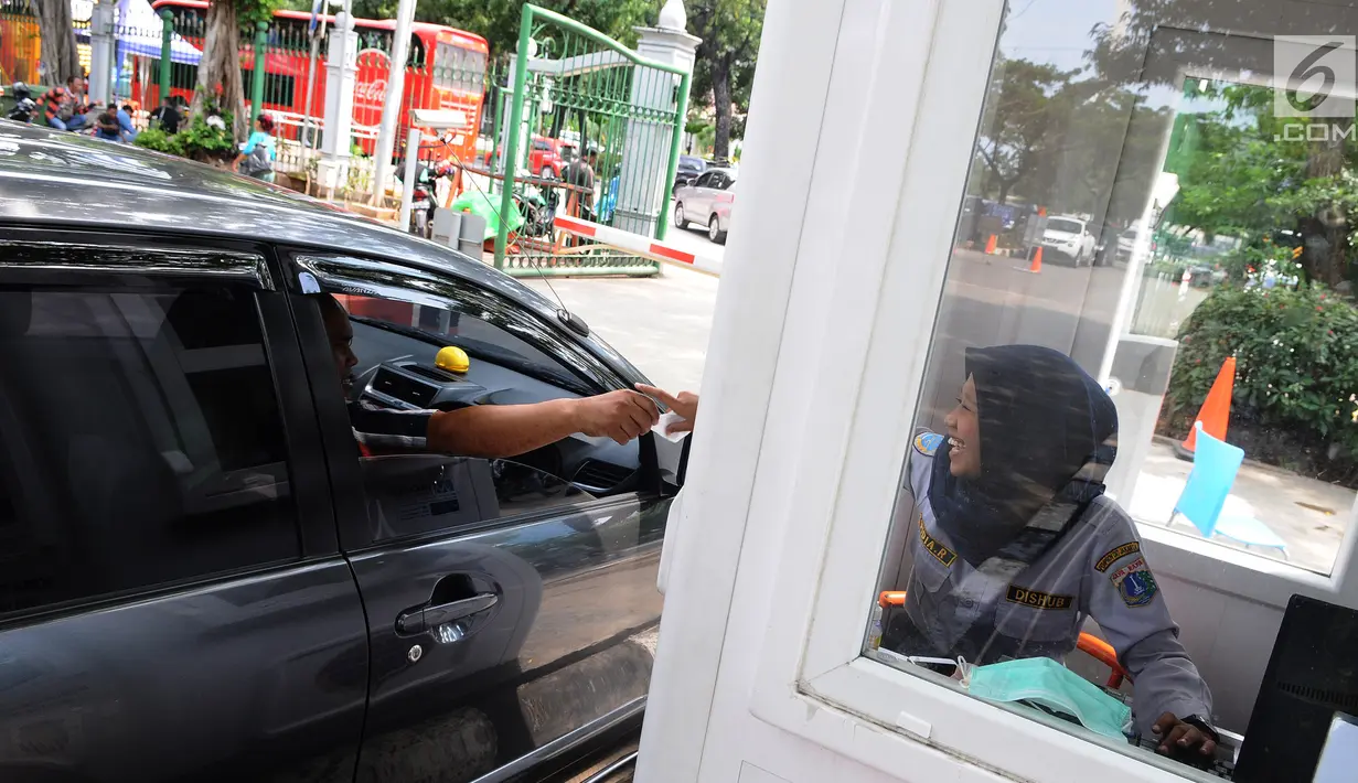 Pengendara mobil memberikan tiket parkir ke petugas di parkiran IRTI kawasan Monas, Jakarta, Jumat (11/1). Pemerintah DKI Jakarta mencabut insentif parkir kendaraan ASN atau PNS di IRTI Monas, Jakarta Pusat. (Liputan6.com/Herman Zakharia)