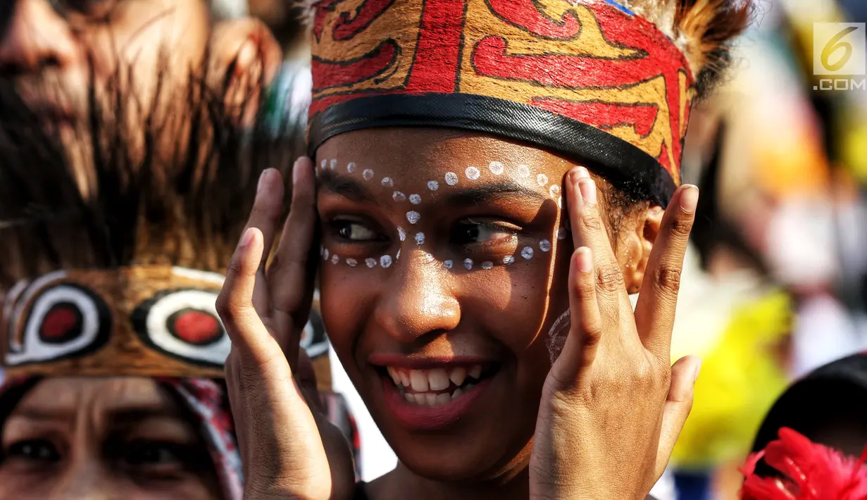 Seorang wanita berdandan dengan mengenakan hiasan kepala saat konser masyarakat Papua di Jakarta pada kegiatan Car Free Day di Bundaran HI, Minggu (1/9/2019). Acara ini digelar untuk mengenalkan budaya Papua kepada para generasi muda keturunan Papua serta masyarakat luas. (Liputan6.com/Johan Tallo)