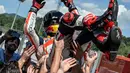 Sebelum naik ke podium, Marc Marquez (atas) merayakan kemenangan bersama tim Honda MotoGP di Sirkuit Mugello, Italia, (1/6/2014). (AFP PHOTO/Andreas Solaro)