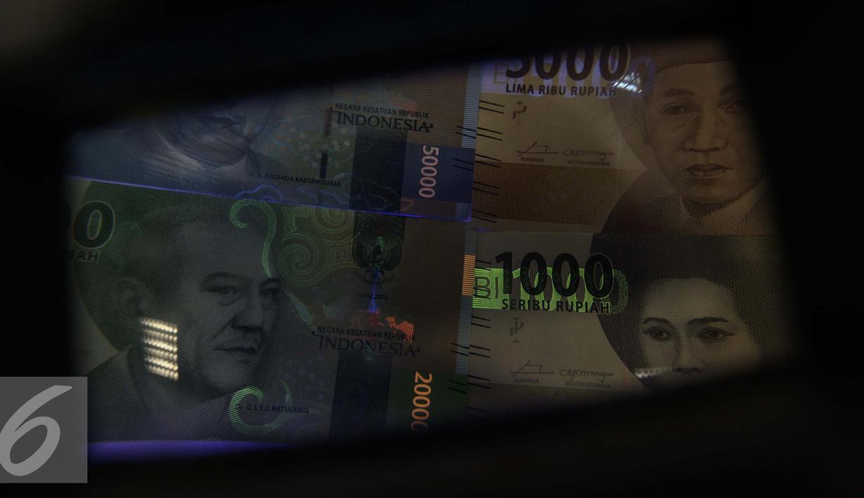 Gambar uang kertas rupiah disinari lampu ultraviolet di kantor Peruri, Karawang, Jawa Barat, Rabu (18/1). Gubernur BI Agus D.W. Martowardojo memaparkan, ada 9-12 pengaman di uang kertas yang diedarkan. (Liputan6.com/Faizal Fanani)