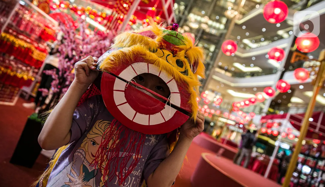 Seorang anak memakai topeng berbentuk barongsai saat mengunjungi Mall Taman Anggrek, Jakarta, Kamis (28/1/2021). Berbagai hiasan memeriahkan perayaan Tahun Baru Imlek 2572 mulai mewarnai pusat perbelanjaan di ibu kota. (Liputan6.com/Faizal Fanani)
