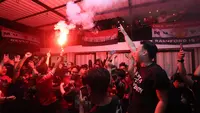 Fans Manchester United menyalakan Flaire saat&nbsp;acara Roaring night Manchester United vs Liverpool di Pitch 98, Kemang, Jakarta Selatan, Minggu (7/4/2024). (Bola.com/M Iqbal Ichsan)