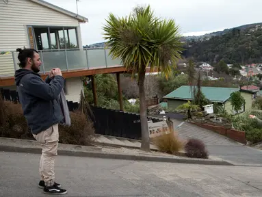 Wisatawan berfoto di tengah Baldwin Street, yang terkenal dengan jalan paling curam di dunia, di kota Dunedin, Selandia Baru, 26 Agustus 2017. Baldwin Street dikenal sebagai jalan paling curam di dunia menurut Guinness World Records. (AP Photo/Mark Baker)