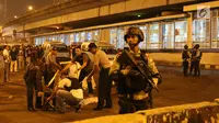 Sejumlah polisi berjaga di sekitar Terminal Kampung Melayu, Jakarta, Rabu (24/5). Polisi dari Polres Jakarta Timur dan Gegana Polda Metro Jaya tengah menyusuri lokasi ledakan. (Liputan6.com/Angga Yuniar)