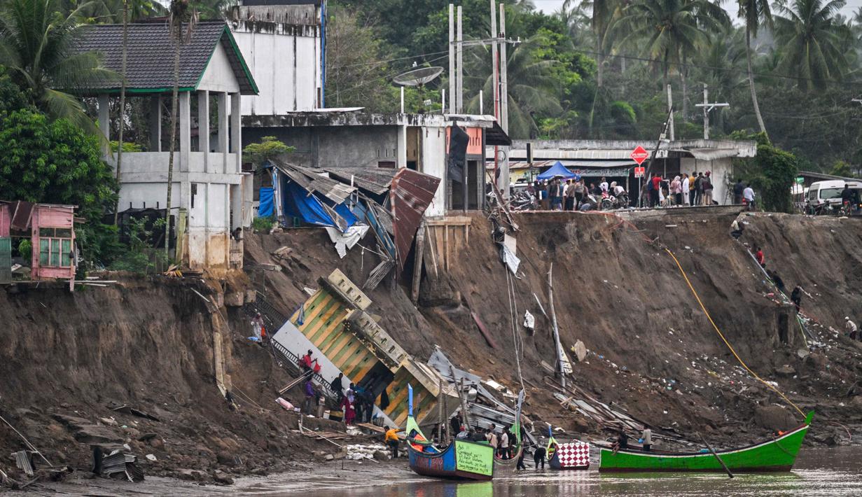 Kerusakan tersebut mengganggu mobilitas warga dan arus lalu lintas. Tampak dalam foto, warga terdampak banjir menaiki perahu untuk menyeberangi Sungai Peusangan di Kuta Blang, Kabupaten Bireuen, Provinsi Aceh, Selasa 9 Desember 2025. (CHAIDEER MAHYUDDIN/AFP)