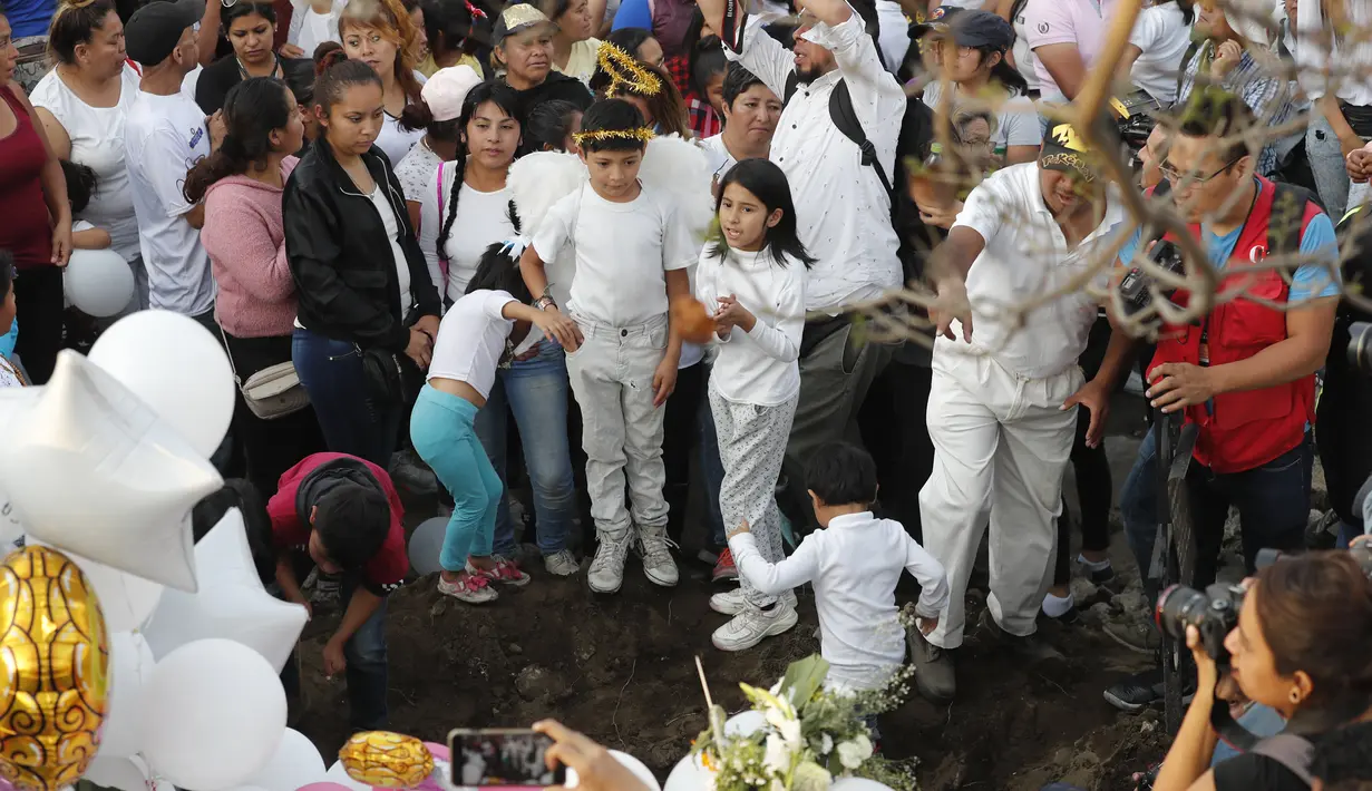 Anak-anak bernyanyi di sebelah kuburan Fatima, korban pembunuhan berusia 7 tahun di Mexico City  (18/2/2020). Jasad Fatima ditemukan terbungkus tas dan ditinggalkan di daerah pedesaan pada hari Sabtu. (AP Photo/Marco Ugarte)