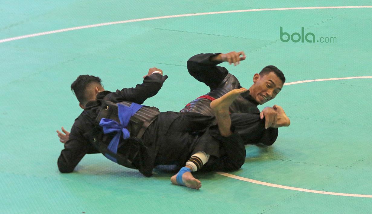 Aksi Arafa M. Yachser (kanan) mengunci pesilat Malaysia, Shukor M. Z. Hakim pada semifinal putra kelas 55 kg - 60 kg Test Event Asian Games  2018 di Padepokan Silat TMII, Jakarta, (12/2/2018). Arafa menang 5-0. (Bola.com/Nick Hanoatubun)