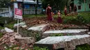 Sejumlah Biksu Buddha membersihkan puing-puing akibat tanah longsor yang merusak pagodha di puncak bukit Kyeik Than Lan Myanmar (18/6). Banjir di Myanmar Selatan juga merendam ratusan rumah. (AFP PHOTO / Ye Aung Thu)