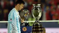 Lionel Messi, diantara trofi juara Copa America yang kembali gagal diraihnya. (AFP PHOTO/RODRIGO ARANGUA)