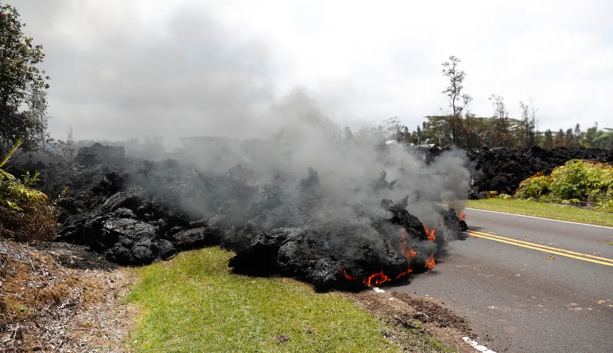 Pemandangan lava pijar erupsi Gunung Kilauea yang menutupi jalan di Hawaii, Amerika Serikat, Sabtu (5/5). Lembaga survei geologi Amerika Serikat (USGS) menyebut aliran lava pijar terjadi akibat retakan dinding kawah Gunung Kilauea. (AP Photo/Marco Garcia)