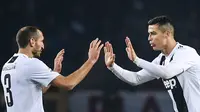 Pemain Juventus, Cristiano Ronaldo (kanan) mendekati Giorgio Chiellini usai mencetak gol ke gawang Torino dalam Serie A Italia di Stadion Olimpiade, Turin, Italia, Sabtu (15/12). Gol Ronaldo menjadi gol ke-5.000 Juventus di Serie A. (Marco BERTORELLO/AFP)