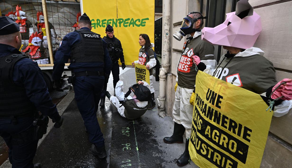 Petugas polisi Prancis terpaksa turun ke lokasi di mana para aktivis Greenpeace melakukan demonstrasi. (Miguel MEDINA/AFP)
