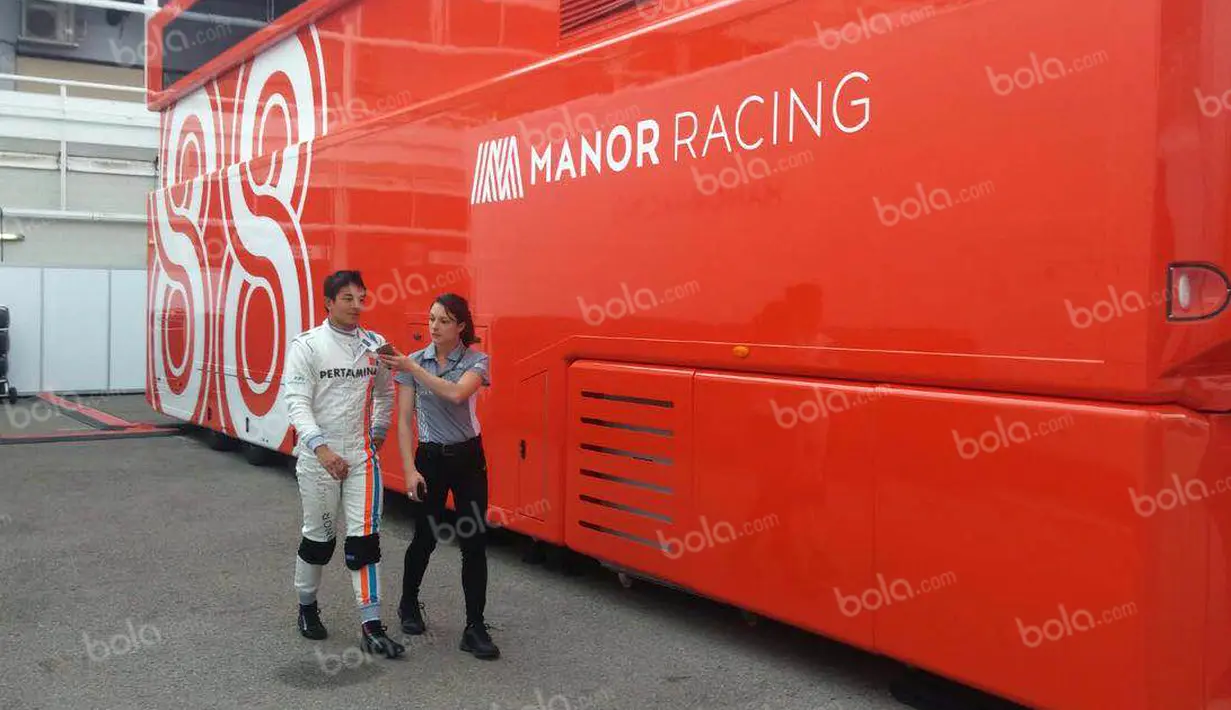 Pebalap Manor Racing asal Indonesia, Rio Haryanto, bersama media officer Manor Racing seusai latihan bebas kedua F1 GP Spanyol di Sirkuit Catalunya, Spanyol, Jumat (13/5/2016). (Bola.com/Reza Khomaini)