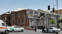 Polisi memasang garis pembatas di sekitar lokasi terjadinya penyerangan bersenjata di parlemen Iran,  Rabu (7/6). Tujuh orang tewas dalam peristiwa ini dan empat orang disandera. (AFP/ATTA KENARE)