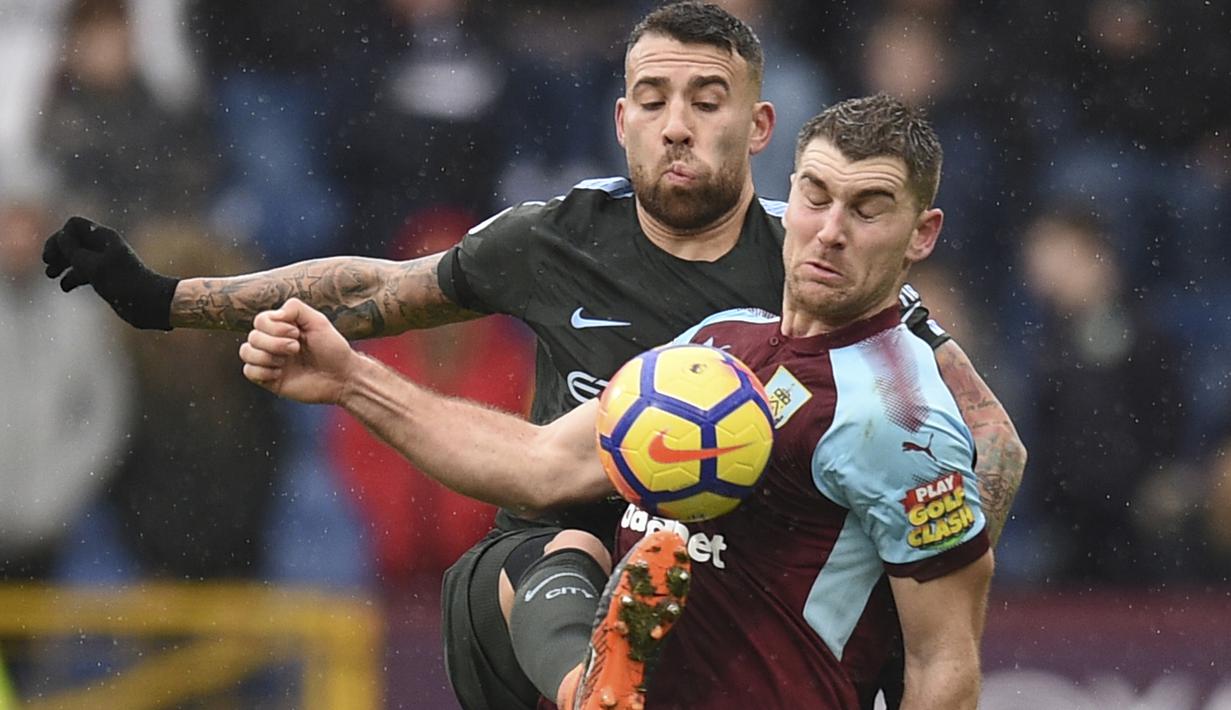 Bek Manchester City, Nicolas Otamendi (kiri) menghalau bola dari dada pemain Burnley, Sam Vokes pada lanjutan Premier League di Turf Moor  Stadium, Burnley, (3/2/2018). Burnley tahan Manchester City 1-1. (AFP/Oli Scarff)