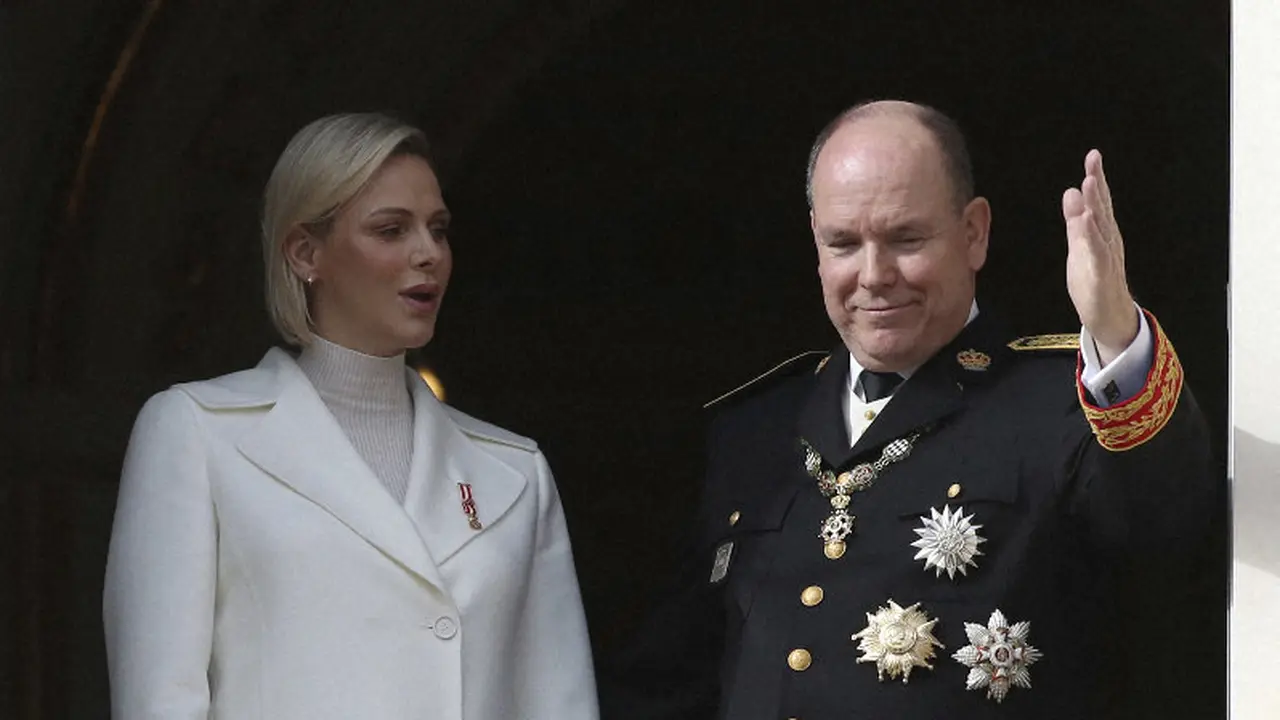 Pangeran Albert II dari Monako (kanan), bersama istrinya Putri Charlene, melambai dari balkon saat upacara menandai Hari Nasional Monako. (Foto: AP/Daniel Cole)