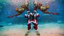 Seorang penyelam yang mengenakan kostum sinterklas dan Rudolph tampil dengan ikan sarden di Coex Aquarium, Seoul, Selasa (18/12). Acara rutin tahunan ini menghadirkan penyelam berpakaian Sinterklas untuk menghibur pengunjung. (AP Photo/Ahn Young-joon)
