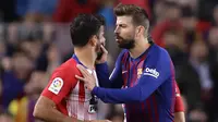 Bek Barcelona, Gerard Pique, berusaha menahan striker Atletico Madrid, Diego Costa, usai dikartu merah wasit pada laga La Liga di Stadion Camp Nou, Sabtu (6/4). Barcelona menang 2-0 atas Atletico Madrid. (AP/Manu Fernandez)