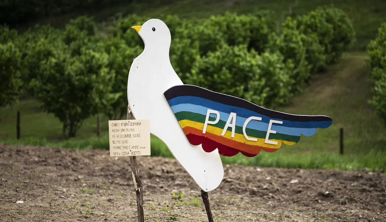 <p>Sebuah gambar pada 3 Mei 2022 menunjukkan merpati kayu yang mewakili perdamaian di sebuah lapangan selama "Pameran Orang-orangan Sawah" tahunan di desa Castellar, Italia utara, dekat Cuneo. Warga menghias orang-orangan sawah layaknya manusia. Seperti mengenakan gaun, kemeja, topi, dan kaca mata lalu menempatkannya di kebun, halaman, ladang serta jalan.(MARCO BERTORELLO / AFP)</p>