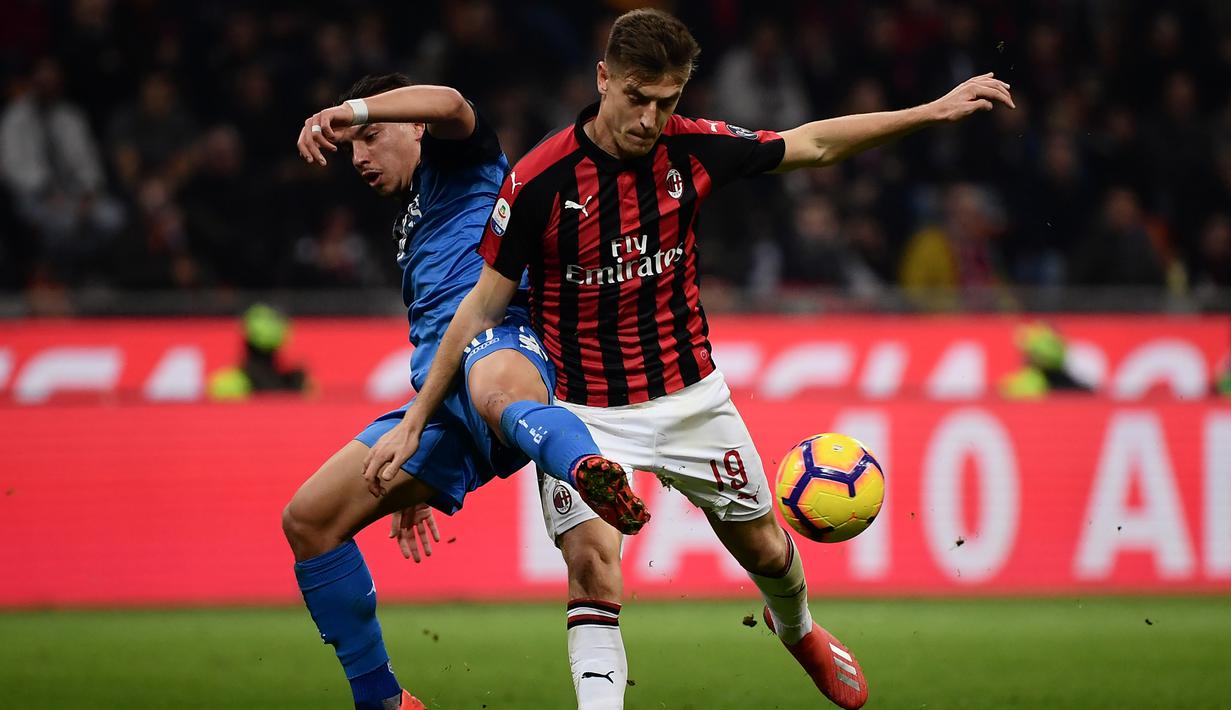 Striker AC Milan, Krzysztof Piatek, berebut bola dengan bek Empoli, Ismael Bennacer, pada laga Serie A di Stadion San Siro, Milan, Jumat (22/2). Milan menang 3-0 atas Empoli. (AFP/Marco Bertorello)