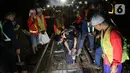 Sejumlah petugas merevitalisasi wesel rel di Stasiun KA Gambir, Jakarta, Kamis (14/2/2020) malam. PT KCI dan PT KAI Daop 1 Jakarta mengganti wesel rel di Stasiun Gambir dan Stasiun Jakarta Kota secara paralel yang akan berlangsung pada 13-23 Februari 2020. (Liputan6.com/Herman Zakharia)