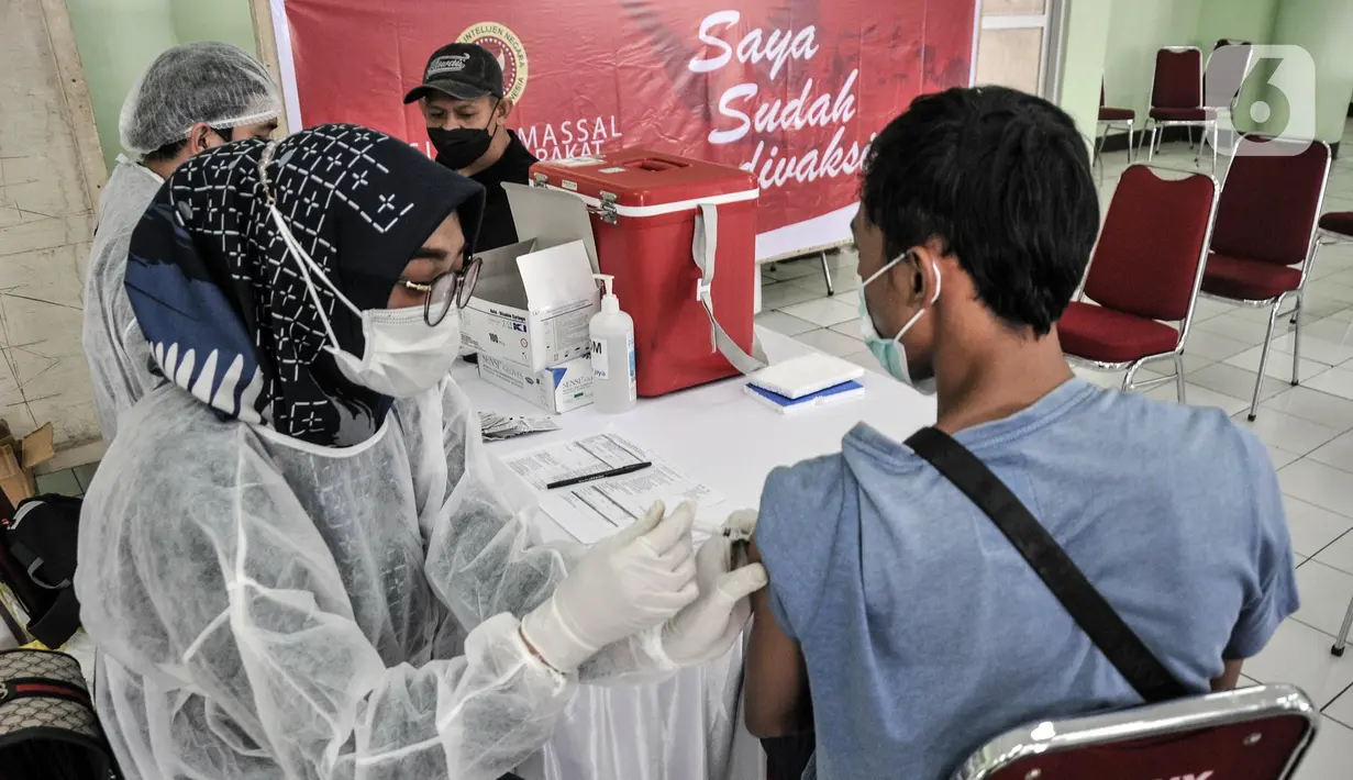 Tenaga kesehatan menyuntik warga saat pelaksanaan vaksinasi dosis ketiga (Booster) di Pasar Induk Kramat Jati, Jakarta Timur, Kamis (10/3/2022). Data terkini mencatat capaian vaksinasi booster COVID-19 di Ibu Kota baru sekitar 1,4 juta orang. (merdeka.com/Iqbal S. Nugroho)