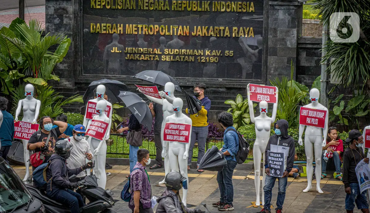 Aktivis membawa manekin dengan poster saat menggelar aksi di depan Polda Metro Jaya, Senin (21/3/2022). Aksi tersebut bentuk dukungan terhadap Haris Azhar dan Fatia Maulidiyanti saat menjalani pemeriksaan terkait kasus dugaan pencemaran nama baik Luhut Binsar Pandjaitan. (Liputan6.com/Faizal Fanani)