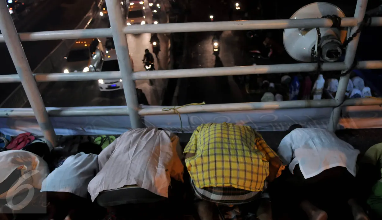 Puluhan warga melaksanakan ibadah Salat Tarawih pertama di kawasan Pasar Gembrong, Jakarta, Rabu (17/6/2015). Terbatasnya jumlah daya tampung musholla membuat warga terpaksa salat di jembatan. (Liputan6.com/Johan Tallo)