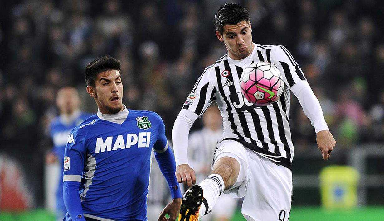 Penyerang Juventus, Alvaro Morata, berusaha melewati gelandang Sassuolo. Pada laga itu Juventus lebih menguasai jalnnya laga dengan penguasan bola 54 persen. (Reuters/Giorgio Perottino)