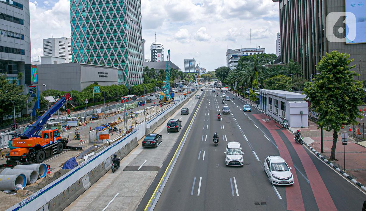 Sejumlah kendaraan melintas disamping proyek pembangunan MRT fase dua di Jalan MH Thamrin, Jakarta, Senin (22/3/2021). Rekayasa lalu lintas tersebut bertujuan untuk kelancaran pengerjaan proyek dan keselamatan serta keamanan bagi pengguna jalan di lokasi tersebut. (Liputan6.com/Faizal Fanani)