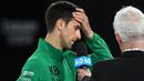 Petenis Serbia, Novak Djokovic, menangis saat diwawancara tentang Kobe Bryant seusai laga Australia Open 2020 di Melbourne, Selasa (28/1). Beri penghormatan dirinya memakai jaket inisial Kobe Bryant. (AFP/Greg Wood)