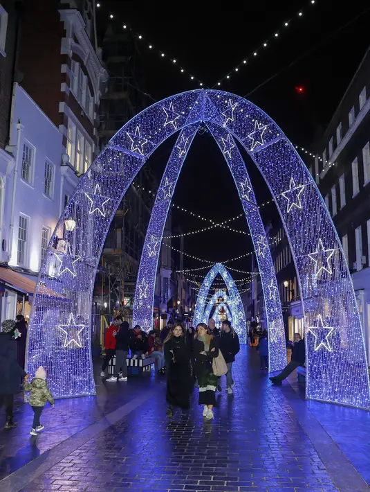 Orang-orang berjalan di sepanjang Bond Street yang dihiasi berbagai dekorasi lampu Natal di pusat kota London, Inggris (30/11/2020). (Xinhua/Han Yan)