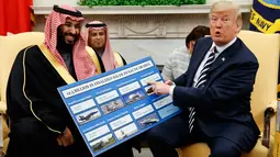 Presiden AS Donald Trump memegang informasi perlengkapan militer AS yang dijual kepada Arab Saudi dalam pertemuan dengan Putra Mahkota Mohammed bin Salman di Gedung Putih, Washington, Selasa (20/3). (AP Photo/Evan Vucci)