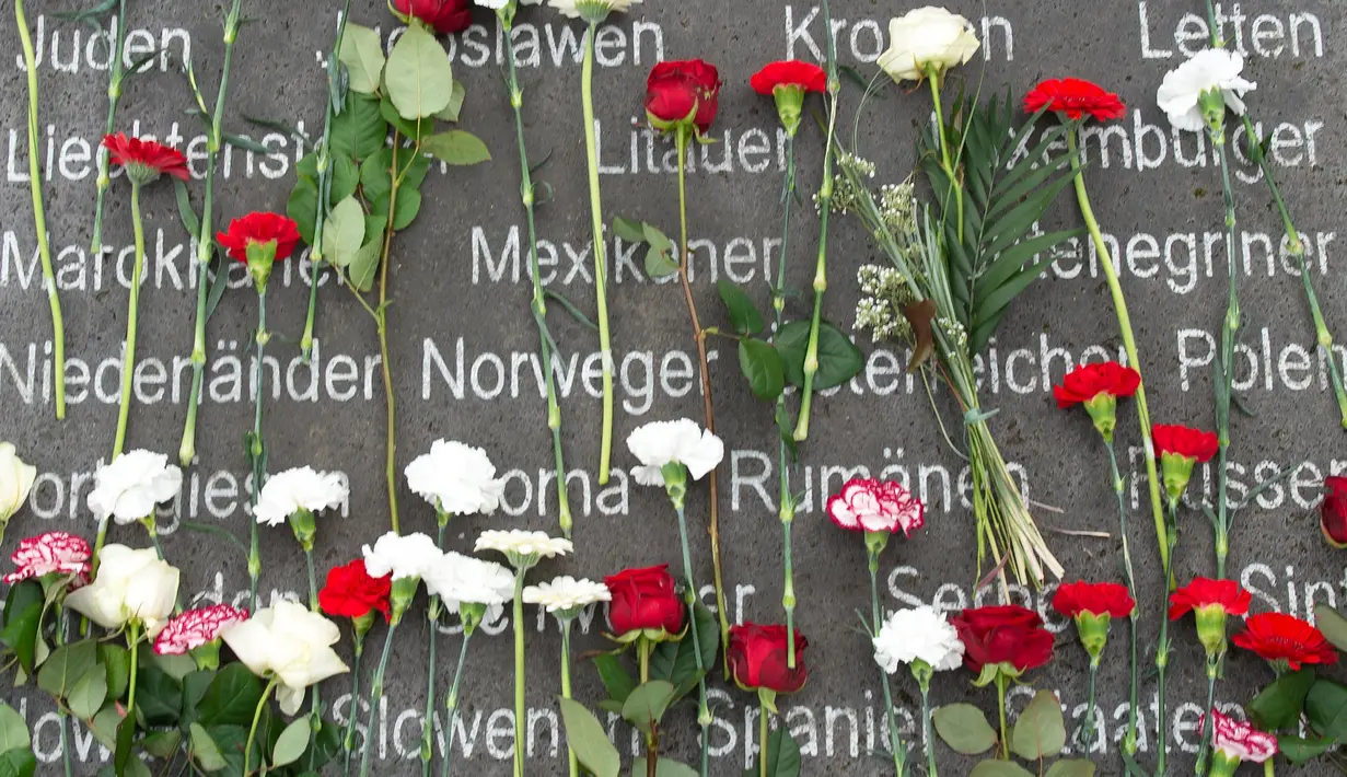 Sejumlah bunga diletakan untuk memperingati 73 tahun pembebasan kamp konsentrasi Nazi di Jerman (11/4). Dalam upacara peringatan ini para mantan korban mengenang kekejian kamp konsentrasi Nazi. (AP Photo / Jens Meyer)