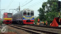 Kereta Commuter Line melintasi lokasi perbaikan kondisi tanah yang longsor di sekitar Kampung Pabuaran, Citayam, Bogor, Rabu (25/11/2015). Sebelumnya, Selasa (24/11) tanah di sekitar rel KM 38 dan 39 mengalami longsor. (Liputan6.com/Helmi Fithriansyah) 