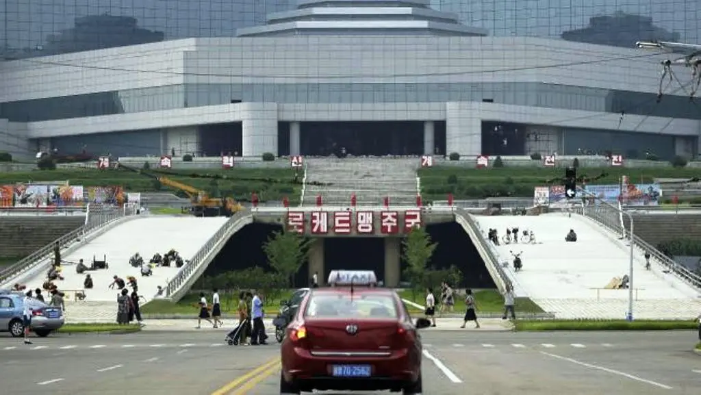 Slogan propaganda terpampang di antara dua jalan masuk menuju Hotel Ryugyong di Korea Utara. (AP)