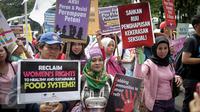 Sejumlah orang yang tergabung dalam beberapa aktivis membawa spanduk saat menggelar aksi unjuk rasa dikawasan Patung Kuda, Jakarta, Rabu (8/3). Peserta aksi menyuarakan penolakan terhadap diskriminasi dan sistem patriarki. (Liputan6.com/Faizal Fanani)