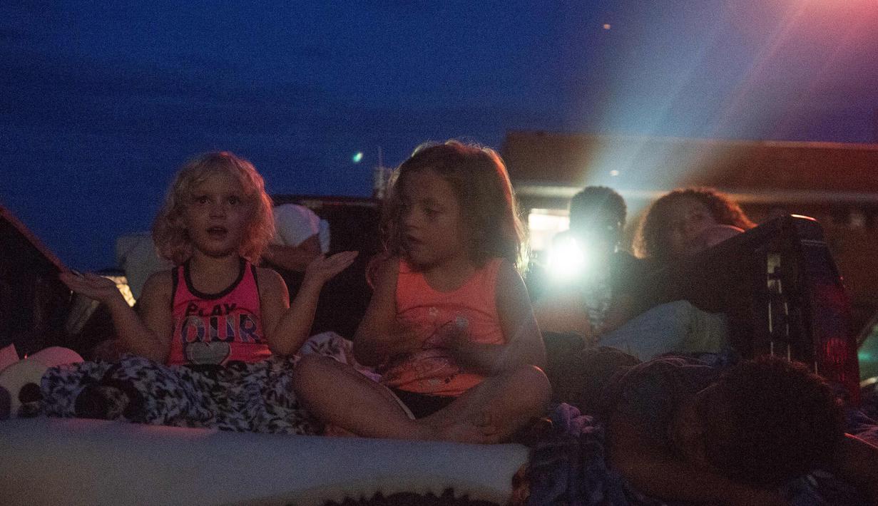 Orang-orang menonton film di luar ruangan saat pemutaran film drive-in di Family Drive-in, Virginia, 10 Agustus 2018. Drive-in merupakan bagian penting dalam industri hiburan di Amerika. (AFP PHOTO/Nicholas Kamm)