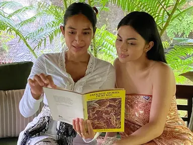 Dalam caption unggahan, Happy Salma menerangkan bahwa dirinya dan Ariel Tatum tidak sengaja menemukan harta karun sebuah buku di library mungil @ibahluxuryvillas. Keduanya pun langsung membaca isi buku tersebut dengan penuh saksama. (Liputan6.com/IG/@happysalma)