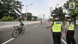 Petugas Dishub dan kepolisian saat menjaga jalannya uji coba lintasan Road Bike di JLNT Kampung Melayu-Tanah Abang, Jakarta, Minggu (23/5/2021). Uji coba lintasan Road Bike tersebut sebagai langkah untuk memfasilitasi arena bagi para pesepeda balap di Ibu Kota. (merdeka.com/Iqbal S Nugroho)