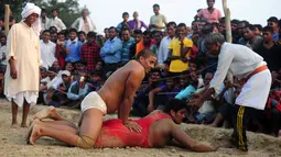 Para pegulat India saat mengikuti kompetisi gulat tradisional India yang diadakan di desa Rampur, India (7/10). Warga setempat mengenal olahraga yang biasa dipertandingkan di tanah ini dengan nama Kusthi. (AFP Photo/Sanjay Kanojia)
