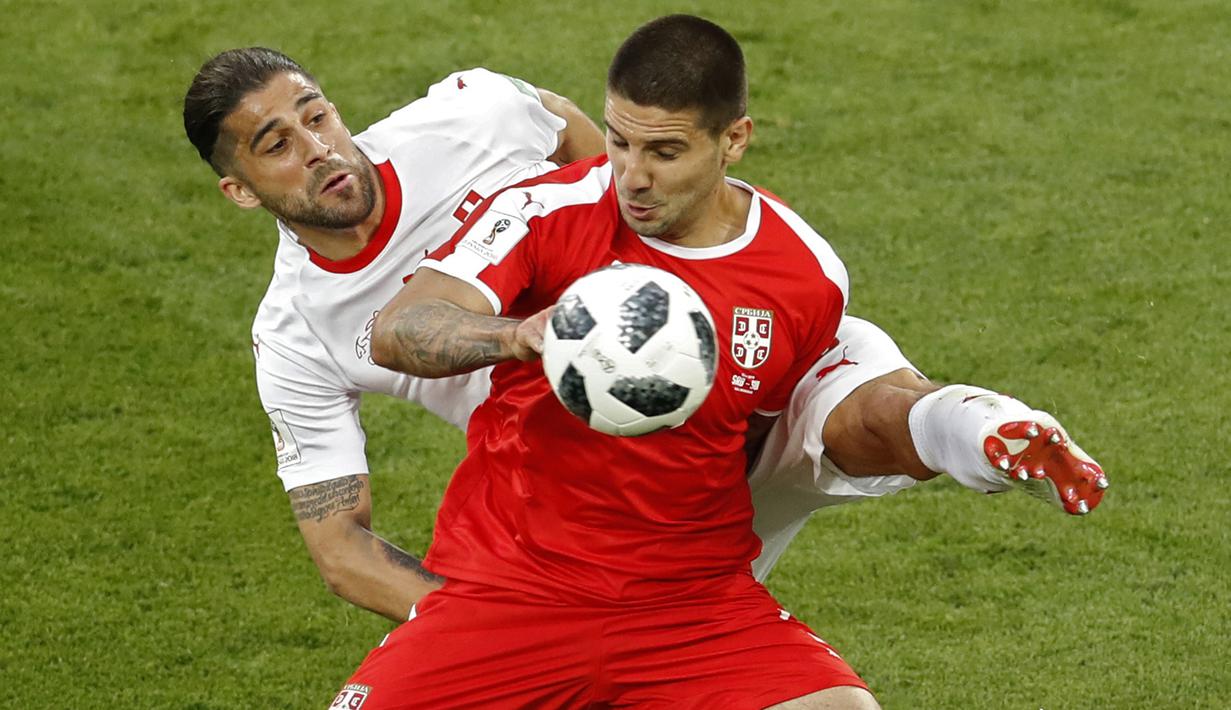 Striker Serbia, Aleksandar Mitrovic, berebut bola dengan bek Swiss, Ricardo Rodriguez, pada laga grup E Piala Dunia di Stadion Kaliningrad, Kaliningrad, Jumat (22/6/2018). Swiss menang 2-1 atas Serbia. (AP/Antonio Calanni)