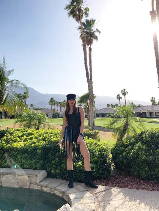 Melihat dari foto-foto yang diunggahnya di akun Instagram, gaya Nia di Coachella tahun ini sangat memikat. Seperti yang satu ini, ia memakai short pants denim dengan atasan hitam yang senada dengan boots dan topinya. (Instagram/ramadhaniabakrie)