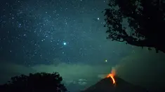 Pemandangan saat Gunung Sinabung memuntahkan lahar dan langit diterangi cahaya bintang di Karo, Sumatera Utara (28/12). Gunung Api Sinabung yang masih berstatus awas level empat kembali erupsi pada Rabu (27/12) sore. (AFP/Lana Priatna)